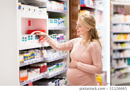 happy pregnant woman with medication at pharmacy happy pregnant woman with medication at pharmacy 31126665