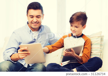 happy father and son with tablet pc at home 31126734