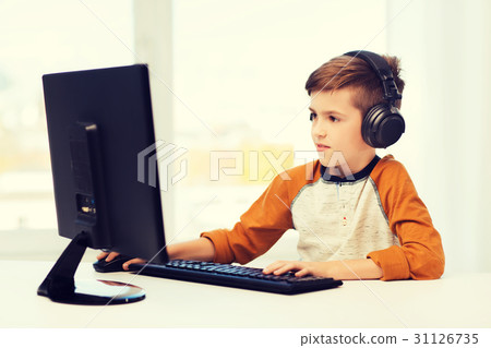 happy boy with computer and headphones at home 31126735