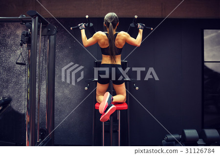 woman exercising and doing pull-ups in gym woman exercising and doing pull-ups in gym 31126784