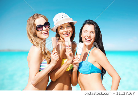 group of smiling women eating ice cream on beach group of smiling women eating ice cream on beach 31127167