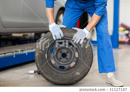 mechanic with wheel tire at car workshop mechanic with wheel tire at car workshop 31127187