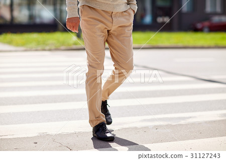 senior man walking along city crosswalk 31127243