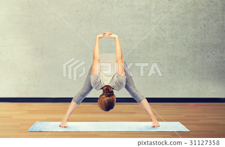 woman making yoga in wide-legged forward bend pose 31127358