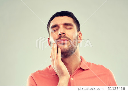 unhappy man suffering from toothache unhappy man suffering from toothache 31127436