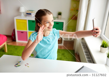 happy girl with smartphone taking selfie at home happy girl with smartphone taking selfie at home 31127602