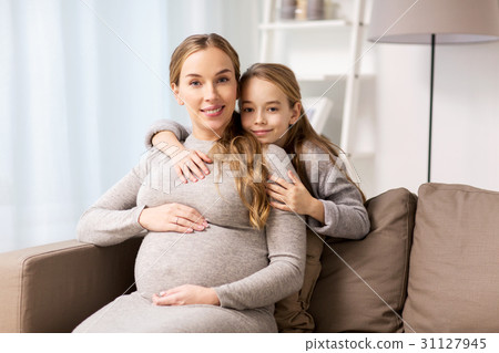 happy pregnant woman and girl hugging at home happy pregnant woman and girl hugging at home 31127945