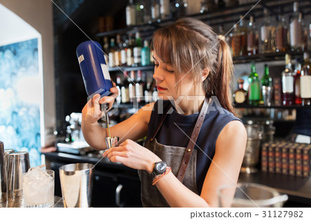 barmaid with shaker preparing cocktail at bar 31127982