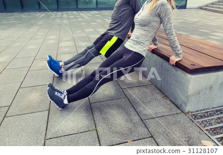 close up of couple doing triceps dip on bench 31128107
