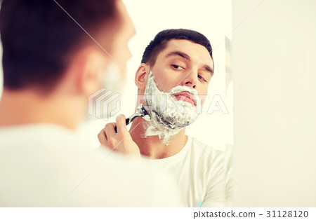 man shaving beard with razor blade at bathroom man shaving beard with razor blade at bathroom 31128120