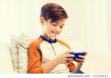boy with smartphone texting or playing at home 31128411