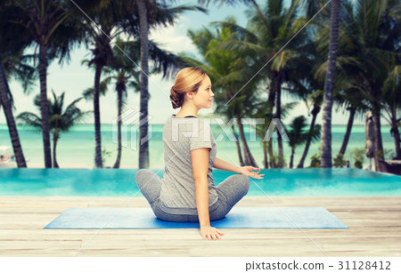 woman making yoga in twist pose on mat 31128412
