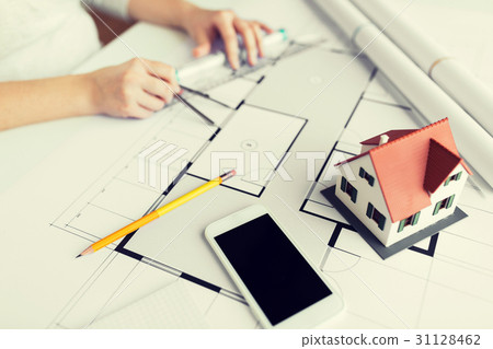 close up of hands with compass measuring blueprint 31128462