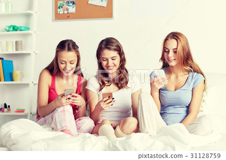 friends or teen girls with smartphone at home friends or teen girls with smartphone at home 31128759