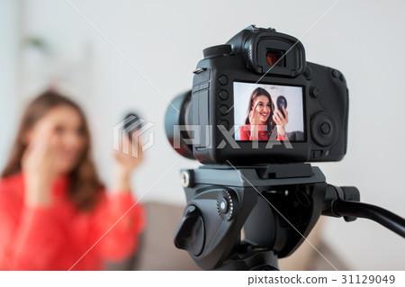 woman with eyebrow pencil recording video at home 31129049