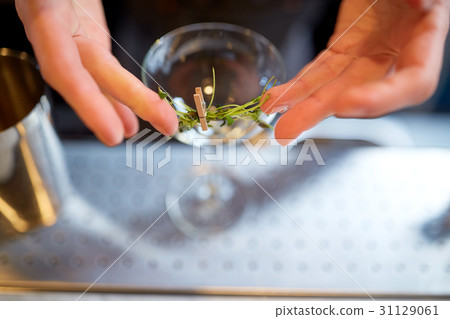 bartender decorating glass of cocktail at bar 31129061
