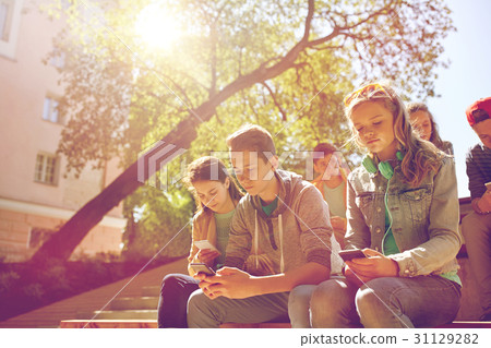 group of teenage friends with smartphones outdoors group of teenage friends with smartphones outdoors 31129282