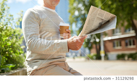 senior man with coffee reading newspaper outdoors 31129298