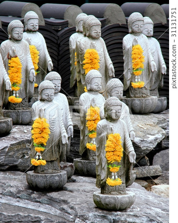 Multiple small buddha statues with yellow garlands Multiple small buddha statues with yellow garlands 31131751