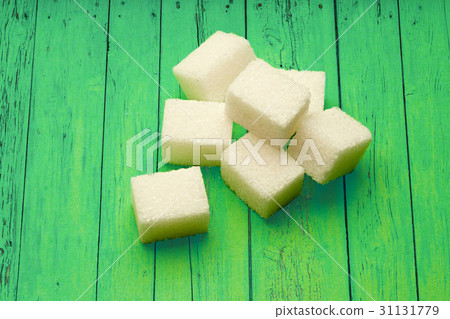 Sugar cubes on green wooden background 31131779