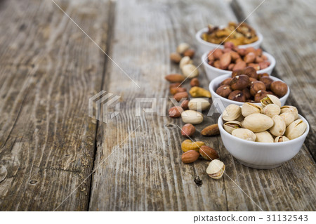 Nuts in a plate on a  wooden table. 31132543