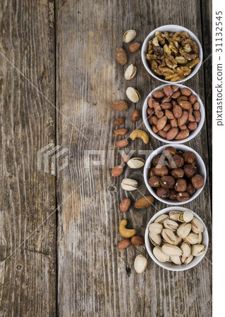 Nuts in a plate on a wooden table. Nuts in a plate on a wooden table. 31132545