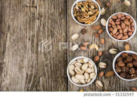 Nuts in a plate on a wooden table. Nuts in a plate on a wooden table. 31132547