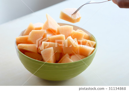 hands using the fork to melt the orange meat 31134868