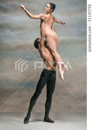 Couple of ballet dancers posing over gray 31135756