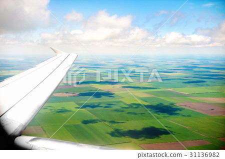 Wing of an airplane flying above the Earth. The 31136982