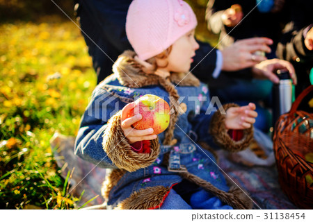 Girl sitting on the grass with an apple Girl sitting on the grass with an apple 31138454