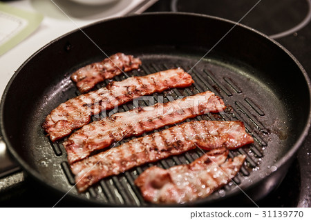 Bacon frying on a stove Bacon frying on a stove 31139770