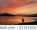 Man on the lake shore contemplates at sunset 31141882