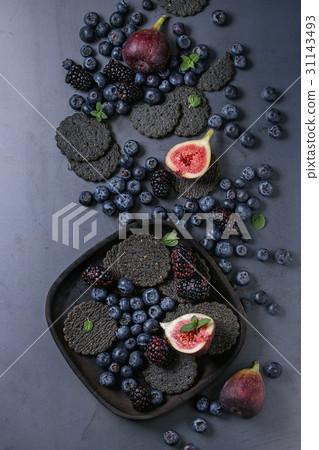 Variety of berries and figs with black crackers 31143493