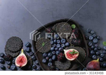 Variety of berries and figs with black crackers 31143498