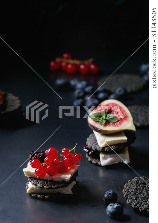 Black crackers with cheese and berries Black crackers with cheese and berries 31143505