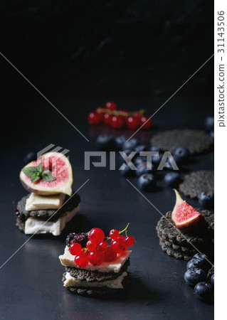 Black crackers with cheese and berries Black crackers with cheese and berries 31143506