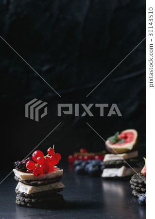 Black crackers with cheese and berries Black crackers with cheese and berries 31143510