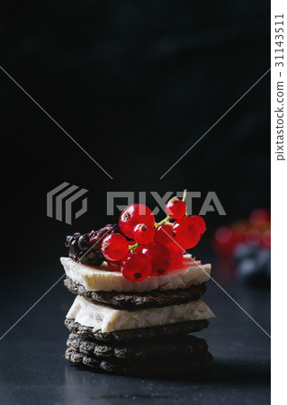 Black crackers with cheese and berries 31143511