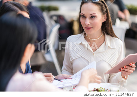 Happy woman telling with colleagues at table 31144657