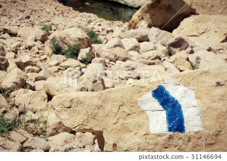 Hiking trail marker painted on a stone in desert  31146694