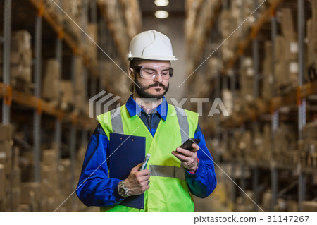 Warehouse worker using mobile phone 31147267