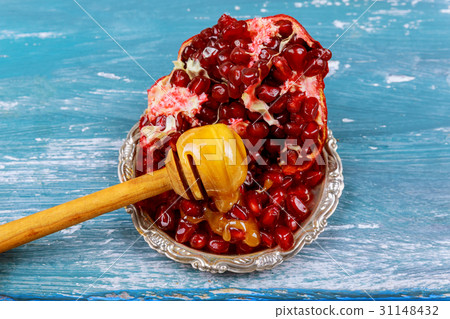 Slices of ripe pomegranate, honey blue wooden Slices of ripe pomegranate, honey blue wooden 31148432