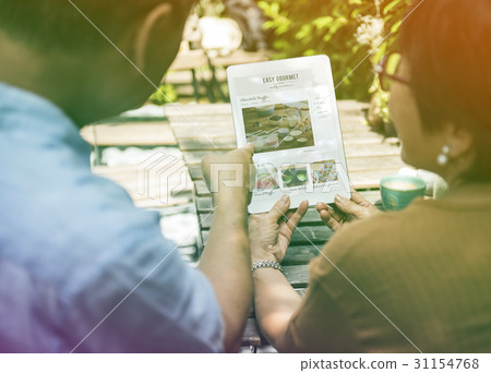 Sweet couple learning pastry on digital tablet Sweet couple learning pastry on digital tablet 31154768