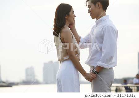 a couple is holding hands and looking into their eyes. a couple is holding hands and looking into their eyes. 31171312