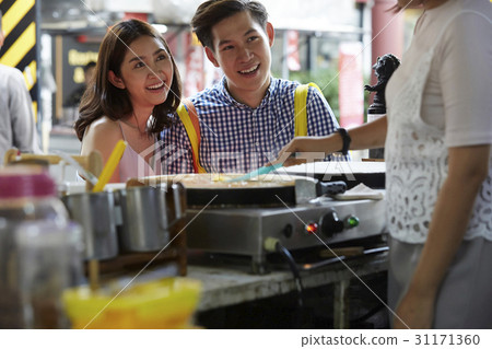 a couple is smiling and waiting to buy a crepe. a couple is smiling and waiting to buy a crepe. 31171360