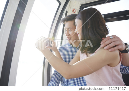 A couple is taking photos with a smartphone. 31171417