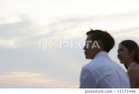 Young couple is watching the sunset together. 31171446