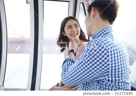a man is touching a happy woman's chin indoors. 31171495