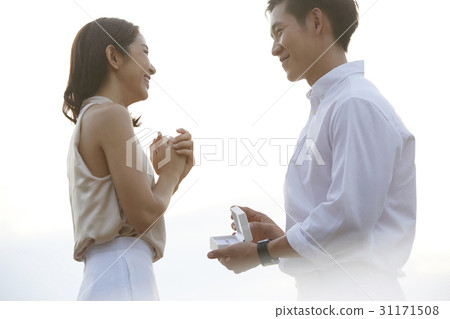Man proposes marriage to his girlfriend. 31171508